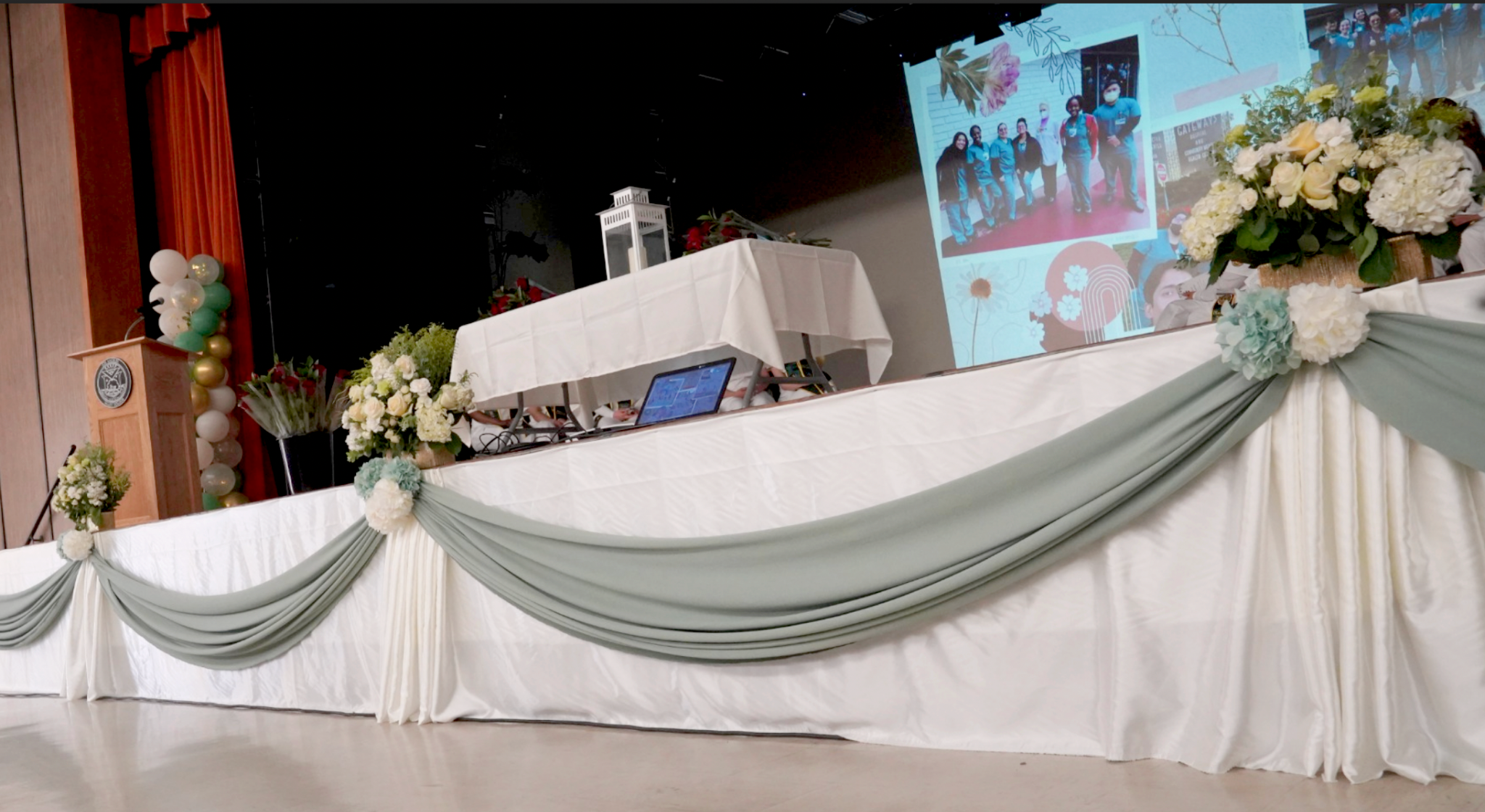 Graduation stage decor with florals, balloons and draping